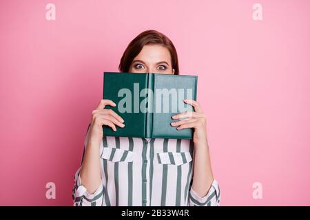 Nahaufnahme des staunenden verrückten Mädchens verstecken ihre Lippen Mund Lesen Buch Lernen Sie unglaubliche Lecture Encyclopedia Informationen tragen Sie moderne Kleidung isoliert Stockfoto