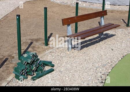 Reparatur der Fußgängerstraße und des grünen Zauns im öffentlichen Park. Natürliche Farben Simplistische sonnige Prägung Stockfoto
