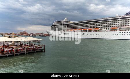 Das riesige Kreuzfahrtschiff MSC Musica dominiert am Abend die Skyline von Venedig, italien. Stockfoto