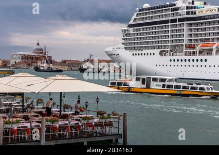 Das riesige Kreuzfahrtschiff MSC Musica dominiert am Abend die Skyline von Venedig, italien. Stockfoto