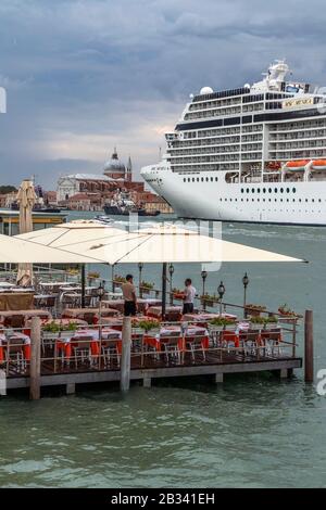 Das riesige Kreuzfahrtschiff MSC Musica dominiert am Abend die Skyline von Venedig, italien. Stockfoto