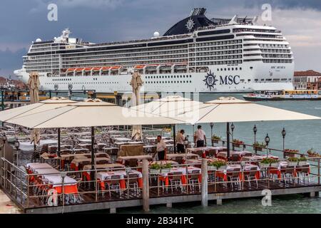 Das riesige Kreuzfahrtschiff MSC Musica dominiert am Abend die Skyline von Venedig, italien. Stockfoto