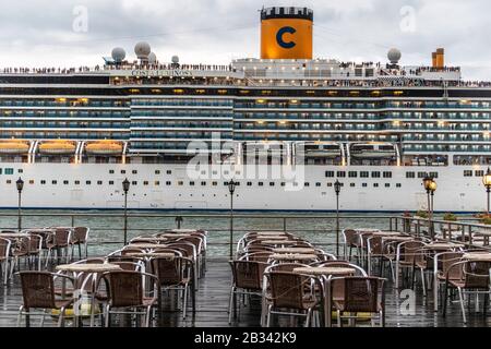 Das riesige Kreuzfahrtschiff Costa Luminosa dominiert die Skyline von Venedig, italien, während es am Abend abfährt. Stockfoto