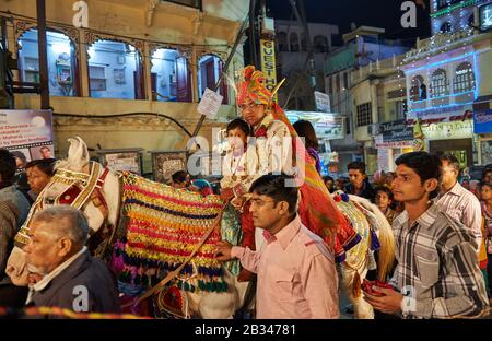 Nachtaufnahme eines Brautzimmers mit Junge und Mädchen auf einem Pferdezug durch die Straßen von Udaipur, Rajasthan, Indien Stockfoto