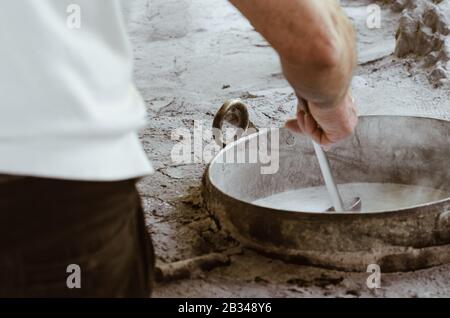 Details des Mannes, der im Freien auf traditionelle Art und Weise Hüttenkäse anstellt. Traditionelle Ricotta-Produktion auf Sizilien an der Madonie. Stockfoto