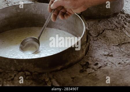 Details des Mannes, der im Freien auf traditionelle Art und Weise Hüttenkäse anstellt. Traditionelle Ricotta-Produktion auf Sizilien an der Madonie. Stockfoto