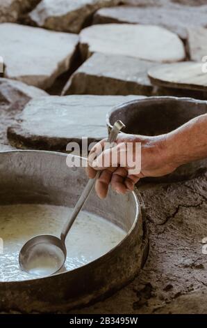 Details des Mannes, der im Freien auf traditionelle Art und Weise Hüttenkäse anstellt. Traditionelle Ricotta-Produktion auf Sizilien an der Madonie. Stockfoto