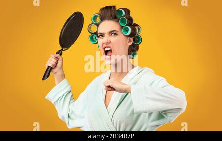 Wütende Hausfrau, Die Braten Pan In Rage Schreit, Studio Erschossen Stockfoto