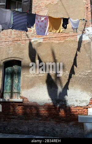 Waschen mit Schatten, die in trockenen, hinteren Straßen von Venedig, Italien hängen Stockfoto