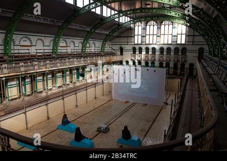 Mitglieder der Public View Specular Reflecular Art Installation in Moseley Road Baths, Birmingham, die handgemalte Animationen enthält, die von 500 lokalen Personen in Verbindung mit dem National Trust erstellt wurden. Stockfoto