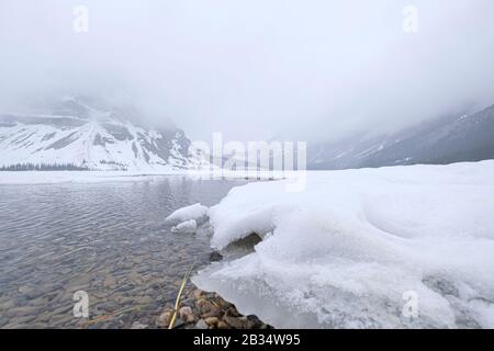 Eine ruhige Szenerie eines ruhigen Sees, umgeben von schneebedeckten Bergen, Jasper, Kanada. Stockfoto