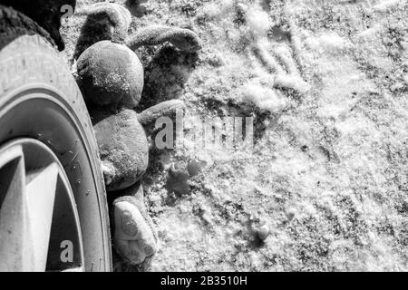 Kinderunfall auf einer Winterstraße, Hase Kaninchen Spielzeug. Tod auf der Straße, Unachtsamkeit und Gefahr. Achtung und Vorsicht. ROADKILL Winter, Konzept. B. Stockfoto