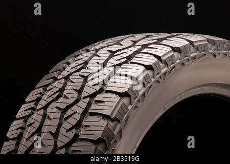 Matador izzarda bei 2-Saison-Geländereifen im Gelände, Seitenwand nah auf dunklem Hintergrund. Stockfoto