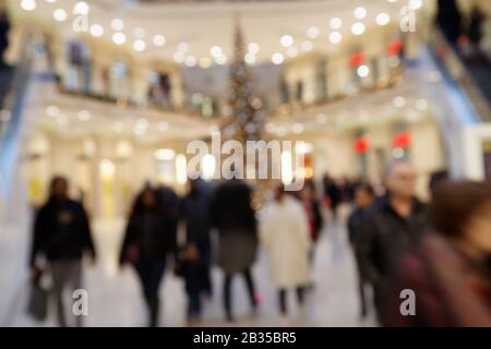 Weihnachtsverkauf: Verschwommene Szene mit dandernden Fußgängern in der stark frequentierten Shopping Mall Stockfoto