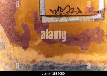 Nahaufnahme der farbenfrohen Orange- und Terrakotta-Schälwand, Italien Stockfoto