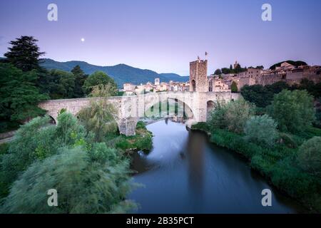 Burg und Festung von Besalu Spanien Vor Sonnenaufgang mit dem Mond am Himmel Stockfoto