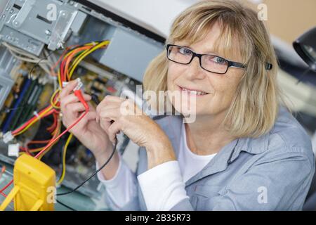 Reifer Techniker während der Spannungsmessung Stockfoto