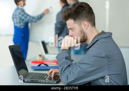 Elektroingenieur, der den Computer während des Kurses betrachtet Stockfoto