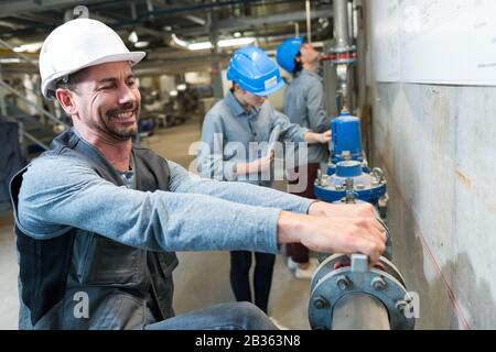 Arbeiter, der Industrieventil mit befestigt Stockfoto