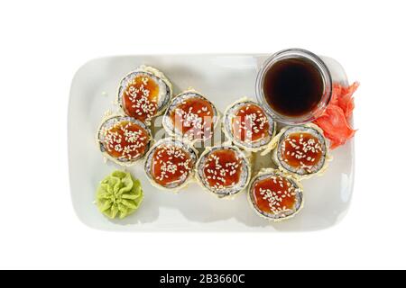 Sushi, Brötchen, Uramaki, Tempura mit Teriyaki-Sauce, Sesam, rohen Meeresfrüchten, Sojasoße, mariniertem Ingwer und Wasabi. Essen auf Platte, weiß isoliert Backgross Stockfoto