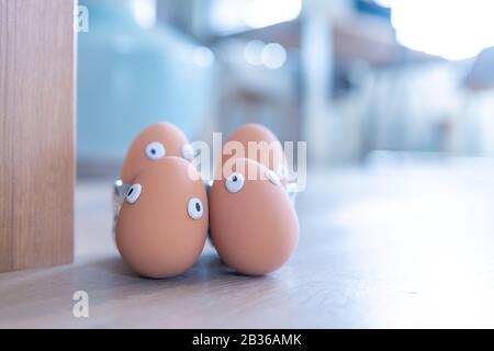 Eine Gruppe von Ostereiern mit lustigen Augen ist am frühen Morgen versteckt, Kinder müssen nach ihnen suchen. Fröhliches Osterkonzept, Osterthema, Hintergrund, Stockfoto