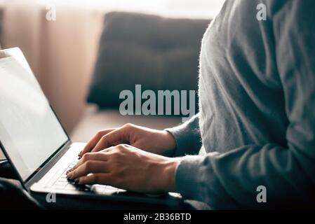 Silhouette eines zugeschnittenen Schusses eines jungen Mädchens, das mit einem Smartphone und einem Notebook-Computer von zu Hause aus arbeitet. Stockfoto