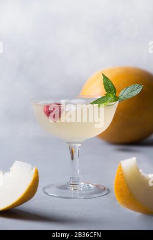 Melonenlemonadegetränk in Glasgarnierraspeln auf grauem Steintisch. Vertikales Format. Nahaufnahme. Stockfoto