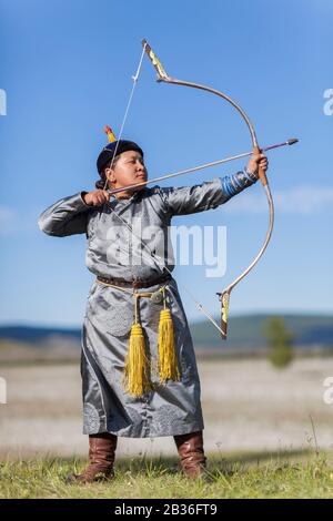 Die Mongolei, die Provinz Khovsgol, das Khatgal-, das Naadam-Festival, die Frau, die Bogenschießen in traditioneller Kleidung betreibt Stockfoto