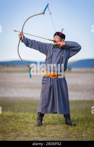 Die Mongolei, die Provinz Khovsgol, das Khatgal- und Naadam-Festival, der Mann, der Bogenschießen in traditioneller Kleidung praktiziert Stockfoto