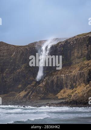 Wasserfall an der Talisker Bay, Skye, Innere Hebriden, scheint aufgrund starker Sturmwinde nach oben zu fließen Stockfoto