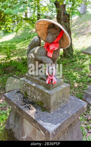 Statue des Kitsune in Strohhut im Inari Shinto Schrein der Burg Aizu-Wakamatsu, Japan. Kitsune ist ein Fuchsgestalter und ein Diener der Inari-Göttin Stockfoto