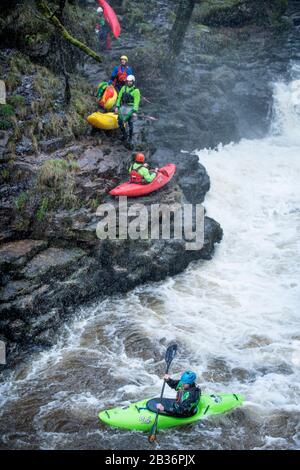 Kajakfahrer nutzen das Hochwasser auf der Melle bei Pontneddfechan in den Brecon Beacons, Wales UK Stockfoto