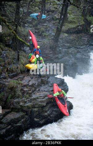 Kajakfahrer nutzen das Hochwasser auf der Melle bei Pontneddfechan in den Brecon Beacons, Wales UK Stockfoto