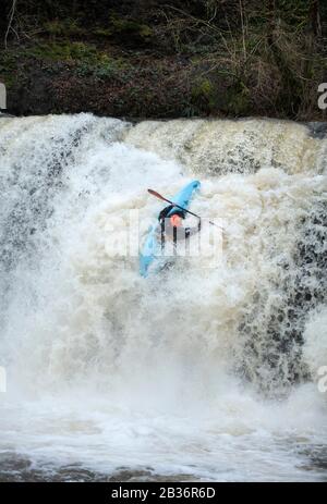 Ein Kajaker nutzt das Hochwasser auf dem Fluss Melle bei Pontneddfechan, um die Sgwd y Pannwr fällt in den Brecon Beacons, Wales UK, zu befahren Stockfoto