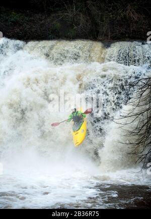 Ein Kajaker nutzt das Hochwasser auf dem Fluss Melle bei Pontneddfechan, um die Sgwd y Pannwr fällt in den Brecon Beacons, Wales UK, zu befahren Stockfoto