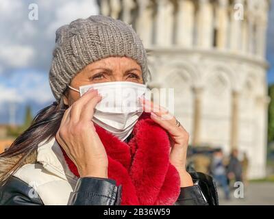 Coronavirus Covid-19 breitet sich über Italien und Europa aus. Frau, die Pisa besucht und eine Gesichtsmaske trägt, um einen Ansteckungsausbruch zu vermeiden. Stockfoto