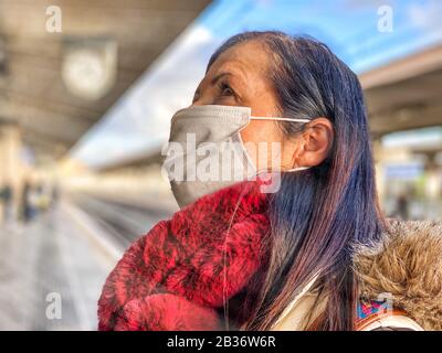 Coronavirus Covid-19 breitet sich über Italien und Europa aus. Frau an der Station, die eine Gesichtsmaske trägt, um einen Ansteckungsausbruch zu vermeiden. Stockfoto