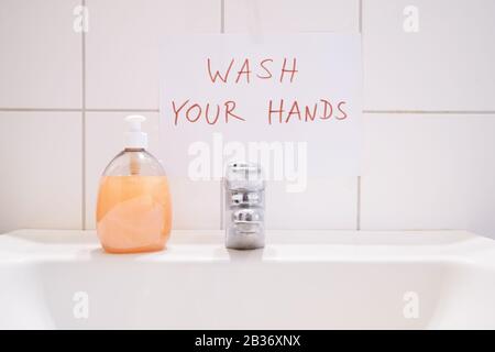 Waschen Sie sich Ihre Hände - handschriftlich mit Hinweisschild über Bad oder WC-Waschbecken - Hygiene verhindert Infektionen Stockfoto