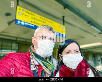 Coronavirus Covid-19 breitet sich über Italien und Europa aus. Das Paar am Bahnhof trägt eine Schutzmaske, um einen Ansteckungsausbruch zu vermeiden. Stockfoto