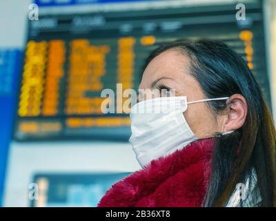 Coronavirus Covid-19 breitet sich über Italien und Europa aus. Frau an der Station, die eine Gesichtsmaske trägt, um einen Ansteckungsausbruch zu vermeiden. Stockfoto