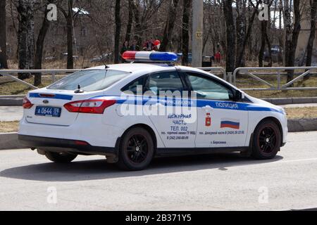 Polizeiauto leuchtet dicht auf. Eine Gruppe von Polizisten im Hintergrund. Russland Berezniki - 01.05.2018 Stockfoto