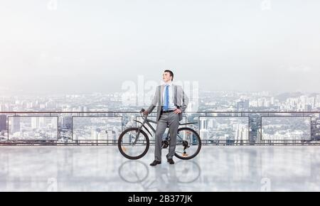 Junge Mann auf dem Balkon, mit Rad Stockfoto