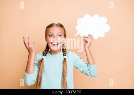 Foto der schönen kleinen Dame halten weiß leeres Papier Wolke Smart School Mädchen haben die richtige Antwort tragen blauen Pullover isoliert beige Pastell Stockfoto