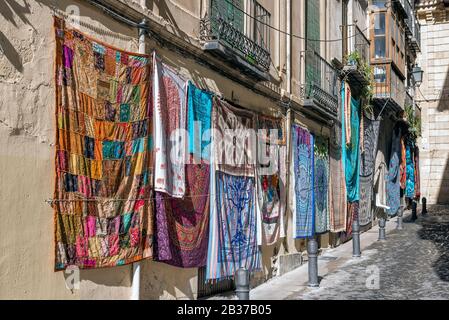 Teppiche in verschiedenen Farben hängen an der Wand in einer Straße. Stockfoto
