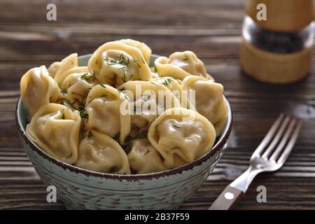 Platte aus traditionellen russischen Knödel, Ravioli auf dunklem Holzhintergrund. Hausgemachte Speisen. Stockfoto