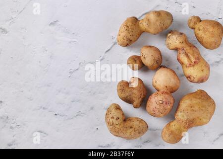 Hässliche Bio-Kartoffeln auf Marmorgrund, Konzept Bio-Gemüse, Copy Space Stockfoto