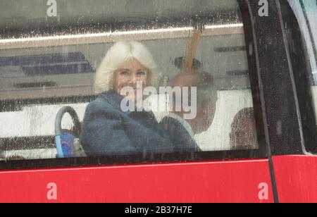 Die Herzogin von Cornwall und ihr Ehemann, der Prince of Wales, in Begleitung des TfL-Kommissars Mike Brown MVO (am weitesten von der Kamera entfernt) Fahren Sie in einem neuen elektrischen Doppeldeckerbus von ihrem offiziellen Wohnsitz im Clarence House in London zum London Transport Museum, um an Feiern zum 20-jährigen Transport von London teilzunehmen. Stockfoto