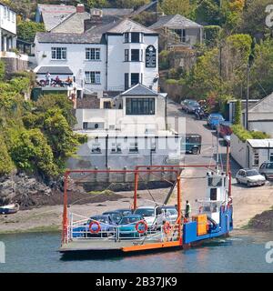 Mit dem Auto beladene Fähre fährt vom Fährhafen Bodinnick Village neben Old Ferry Inn über den Fluss Fowey zur Stadt Fowey Cornwall England UK Stockfoto