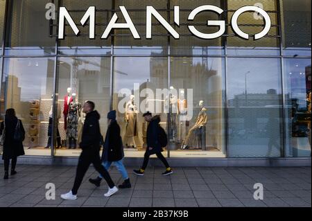 Die Menschen gehen an einer spanischen Bekleidungsladenkette Mango vorbei. Stockfoto