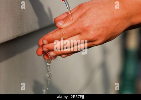 Waschen Sie die Hände, ein Mann wäscht seine Hände unter dem Hahn mit Seife und Wasser. Ein Mann spült seine Hände unter fließendem Wasser Stockfoto